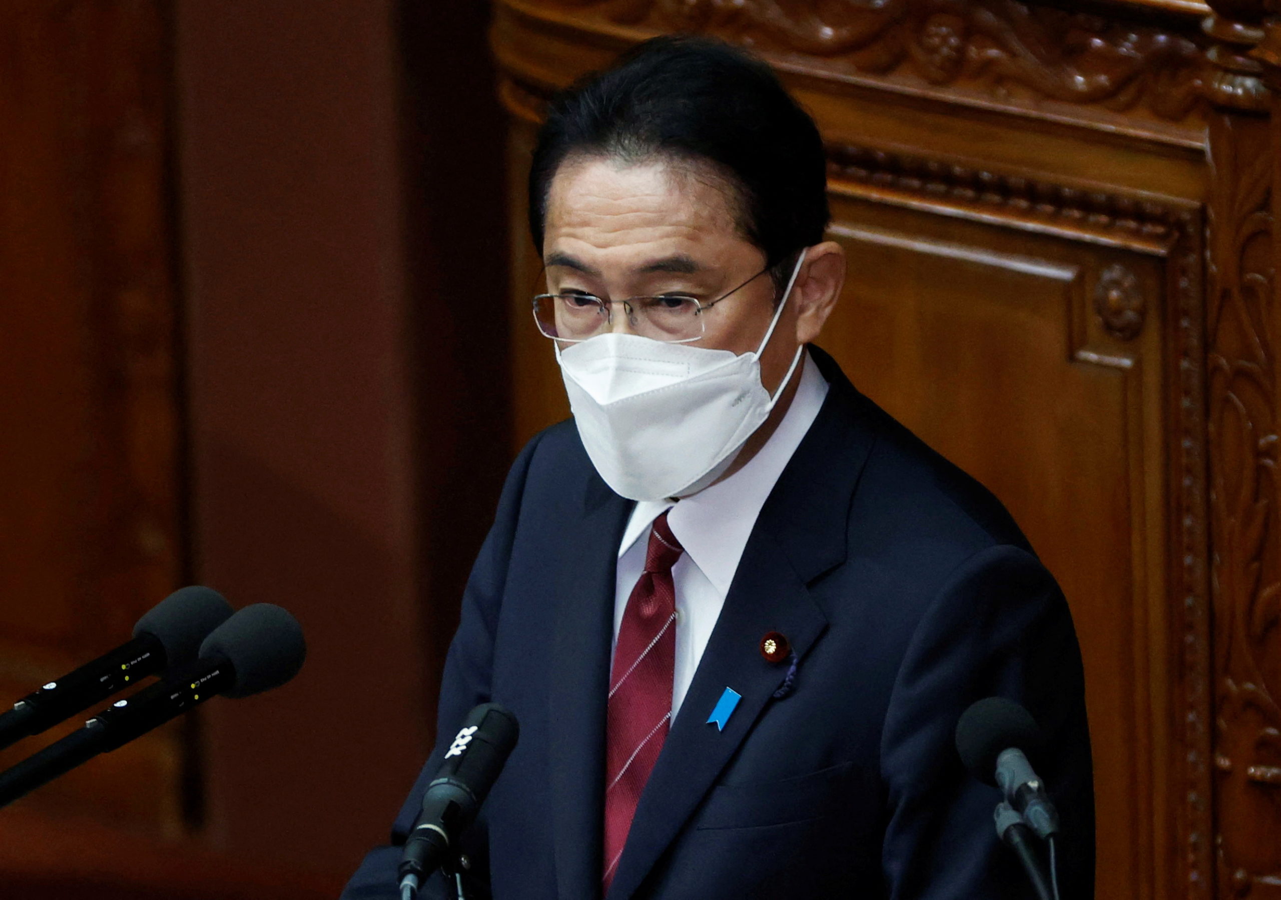 FILE PHOTO: Japan's Prime Minister Fumio Kishida wearing a protective face mask delivers his policy speech at the start of an extraordinary session of the lower house of the parliament, amid the coronavirus disease (COVID-19) pandemic, in Tokyo, Japan December 6, 2021. 