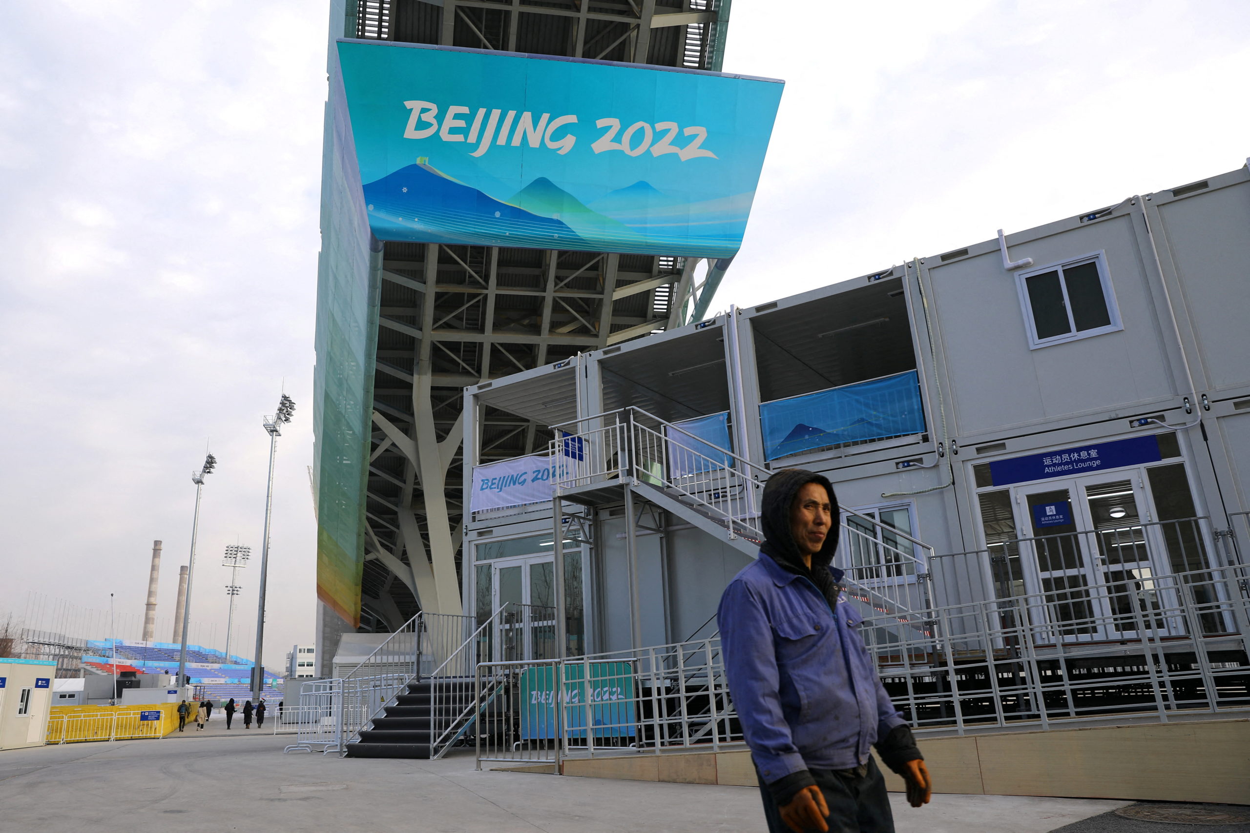 A worker walks under the Big Air Shougang, a competition venue for freestyle skiing and snowboard at the Beijing 2022 Winter Olympics, during an organised media tour, in Beijing, China December 15, 2021. 