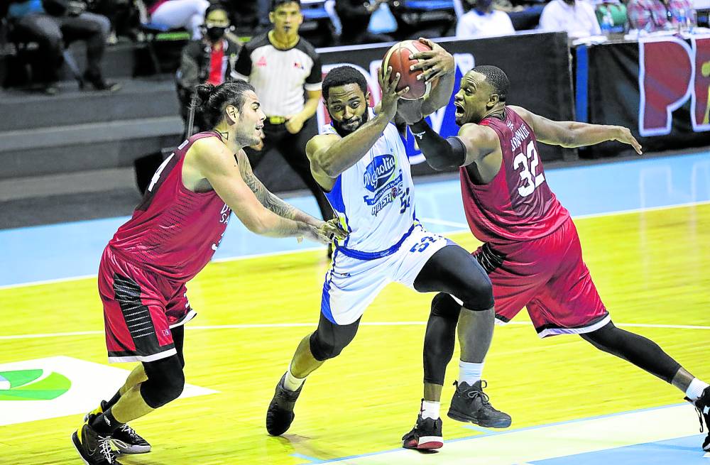 Magnolia import Mike Harris drives against the defense of Barangay Ginebra’s Christian Standhardinger (left) and Justin Brownlee (right) in Saturday night’s Christmas Day match between the rival clubs