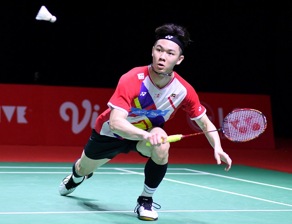 This handout photo taken and released on December 2, 2021 by the Badminton Association of Indonesia shows Malaysia’s Lee Zii Jia hitting a return against France’s Toma Junior Popov during their men's singles elimination badminton match at the BWF World Tour Finals in Nusa Dua on the resort island of Bali.