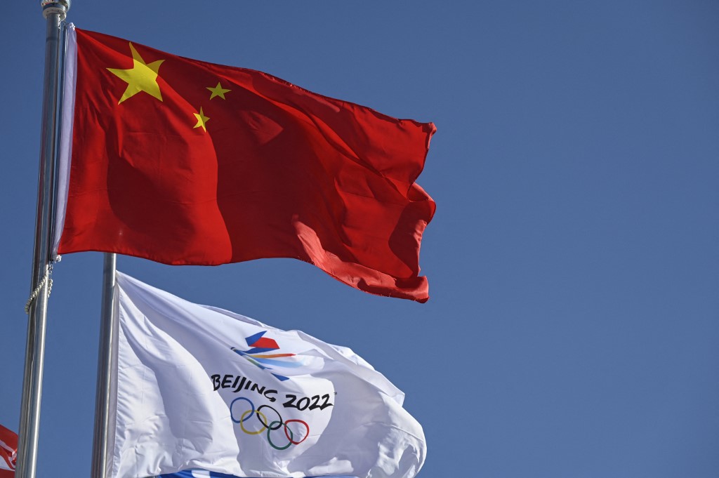 A Chinese flag and a Beijing 2022 Winter Olympics flag flutter at the Beijing Winter Olympic Games village in Beijing on December 24, 2021.