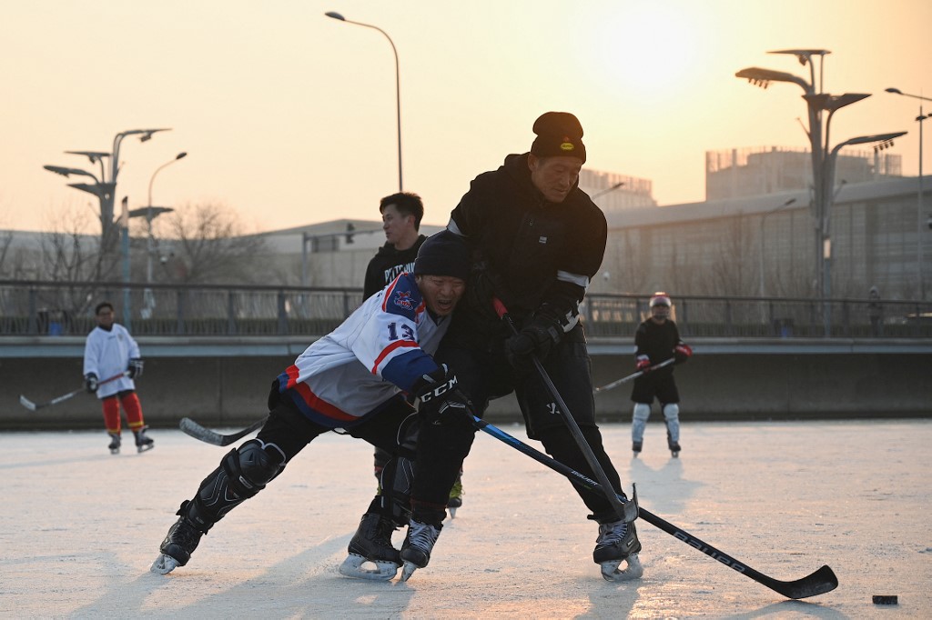 2022 年 1 月 5 日，人们在北京奥林匹克公园的一条结冰的运河上打冰球，北京将于 2 月 4 日举办 2022 年冬季奥运会。 