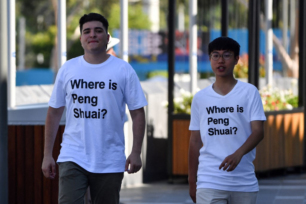 Australian human rights campaigner Drew Pavlou (L) is pictured wearing a "Where is Peng Shuai?" T-shirt, referring to the former doubles world number one from China, on the grounds outside one of the venues on day nine of the Australian Open tennis tournament in Melbourne on January 25, 2022.