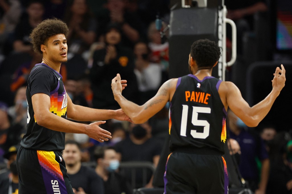 FILE– Cameron Johnson #23 of the Phoenix Suns reacts with Cameron Payne #15.