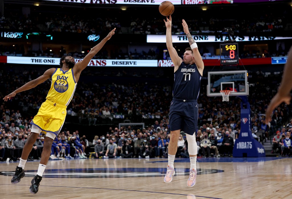 Luka Doncic #77 of the Dallas Mavericks shoots the ball against Andrew Wiggins #22 of the Golden State Warriors in the first quarter at American Airlines Center on January 05, 2022 in Dallas, Texas. 