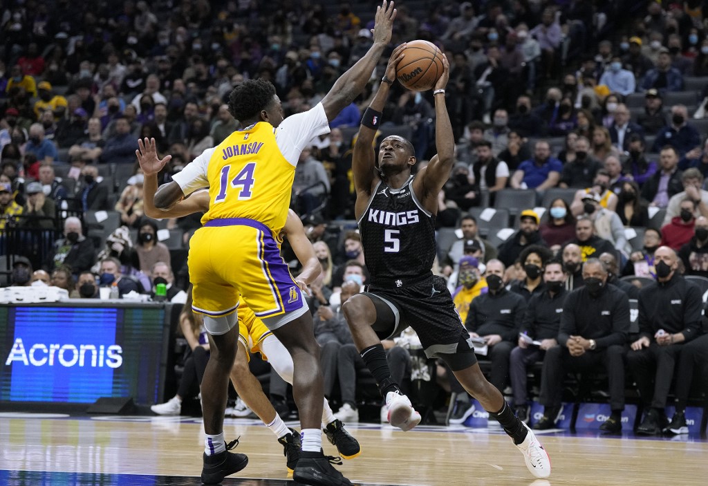 De'Aaron Fox #5 of the Sacramento Kings drives to the basket on Stanley Johnson #14 of the Los Angeles Lakers during the first quarter at Golden 1 Center on January 12, 2022 in Sacramento, California. 