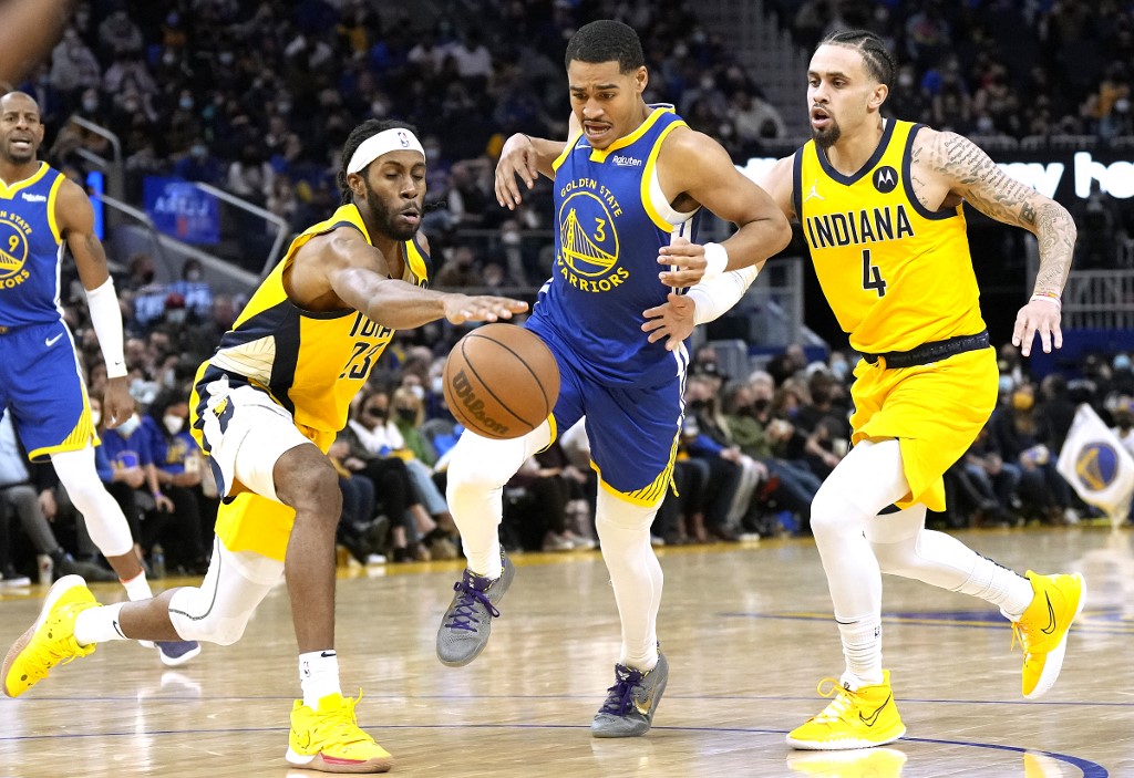 Jordan Poole #3 of the Golden State Warriors dribbles between Isaiah Jackson #23 and Duane Washington Jr. #4 of the Indiana Pacers during the second half of an NBA basketball game at Chase Center on January 20, 2022 in San Francisco, California. 