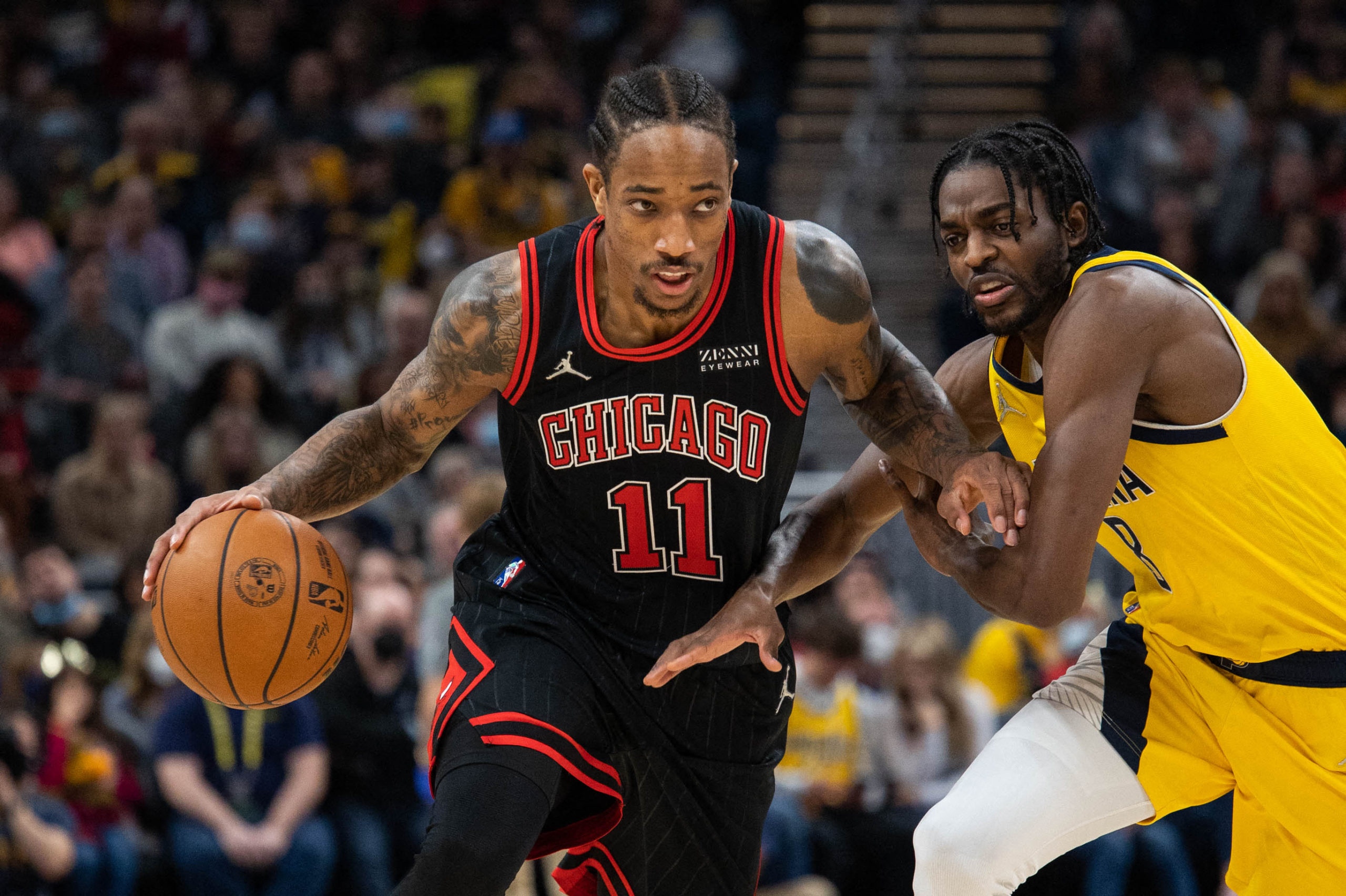 Chicago Bulls forward DeMar DeRozan (11) dribbles the ball while Indiana Pacers forward Justin Holiday (8) defends in the second half at Gainbridge Fieldhouse.
