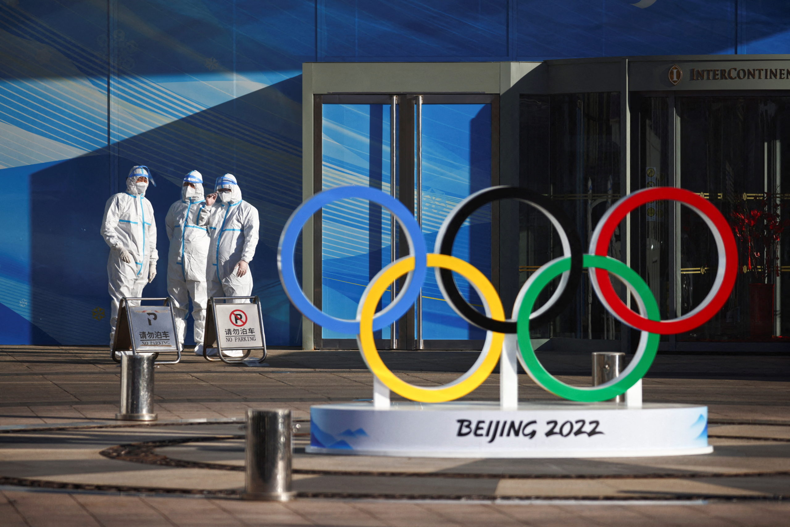 FILE PHOTO: Workers in PPE stand next to the Olympic rings inside the closed loop area near the National Stadium, or the Bird's Nest, where the opening and closing ceremonies of Beijing 2022 Winter Olympics will be held, in Beijing, China December 30, 2021. REUTERS/Thomas Peter