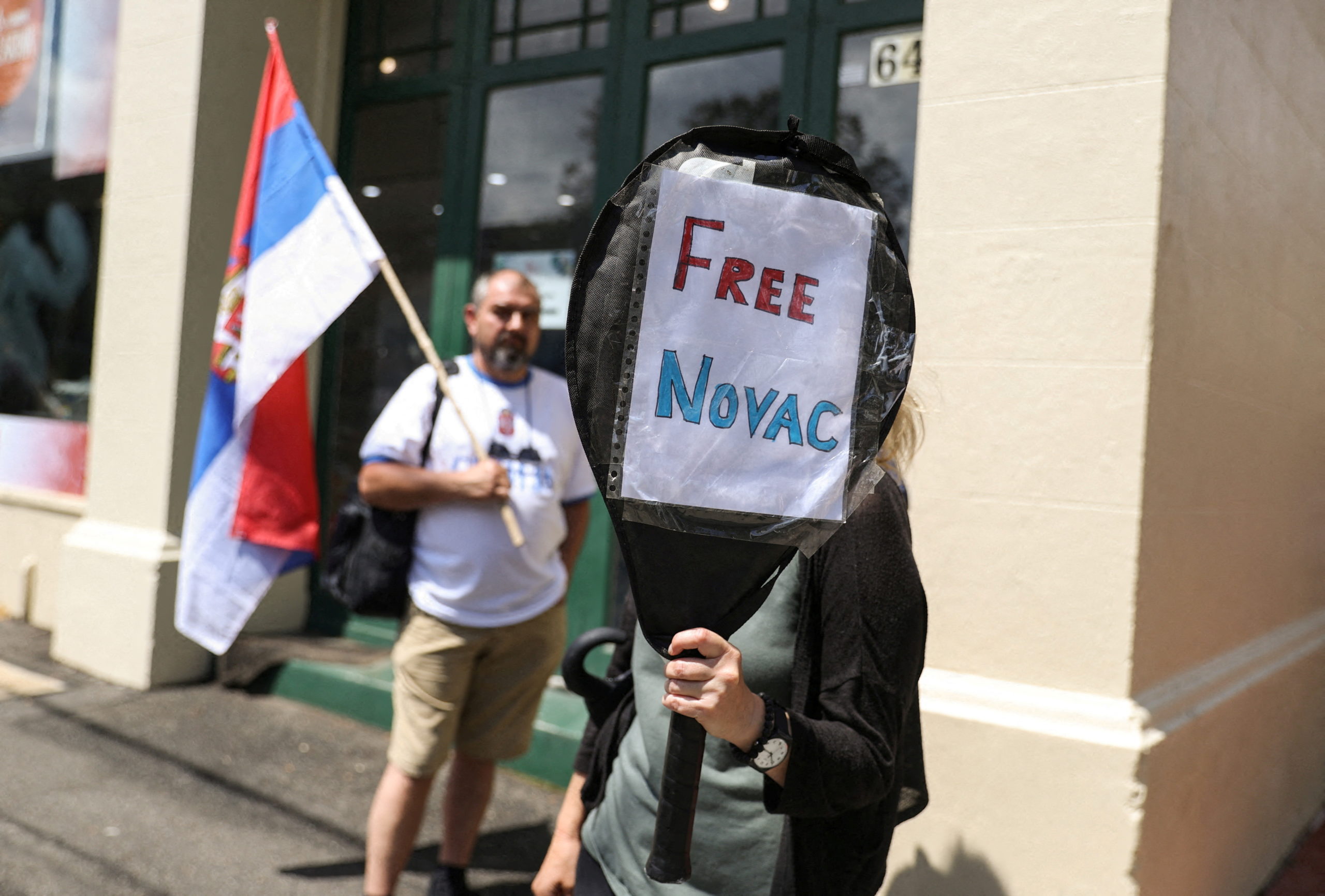 FILE PHOTO: A supporter of Serbian tennis player Novak Djokovic holds up a sign outside the Park Hotel, where the star athlete is believed to be held while he stays in Australia, in Melbourne, Australia, January 7, 2022.