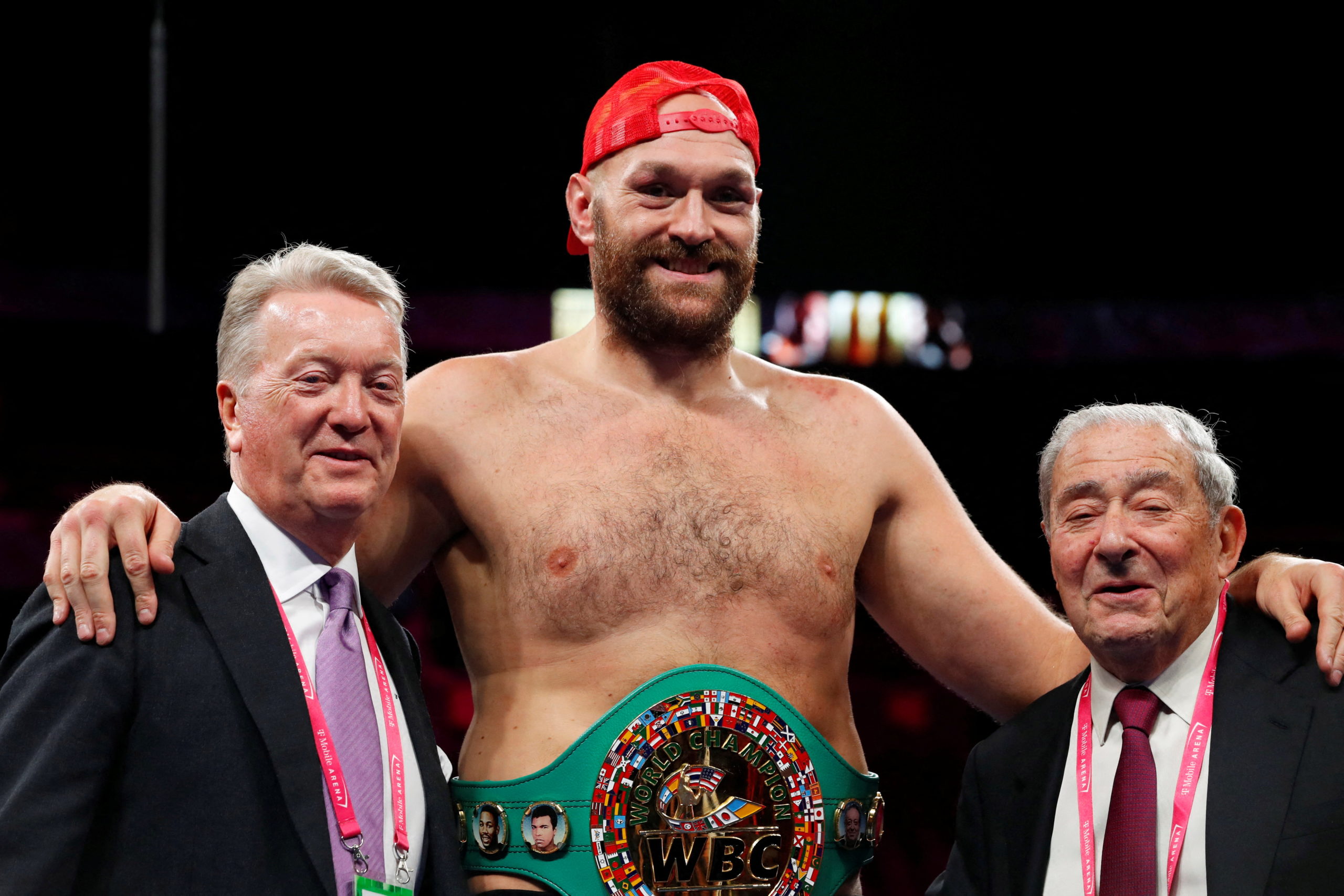 FILE PHOTO: Boxing - Tyson Fury v Deontay Wilder - WBC Heavyweight Title - T-Mobile Arena, Las Vegas, Nevada, U.S. - October 9, 2021 Tyson Fury poses for a photograph with promoters Frank Warren and Bob Arum during a press conference after winning the fight against Deontay Wilder