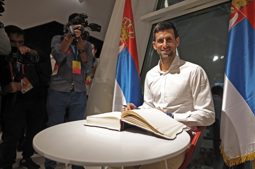 Serbian Tennis player Novak Djokovic (R) signs a visitors book during a visit to the Serbian pavillion at the Expo 2020 in Dubai, on February 17, 2022. 