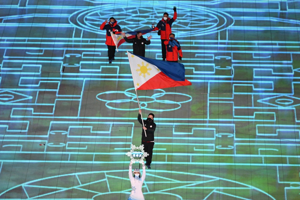 Philippines' flag bearer Asa Miller leads the delegation as they enter the stadium during the opening ceremony of the Beijing 2022 Winter Olympic Games, at the National Stadium, known as the Bird's Nest, in Beijing, on February 4, 2022.