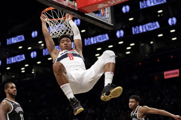 Rui Hachimura #8 of the Washington Wizards hangs on the basket after dunking in front of LaMarcus Aldridge #21 of the Brooklyn Nets during the second half at Barclays Center on February 17, 2022 in New York City.