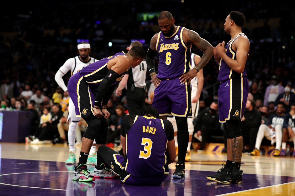  Russell Westbrook #0, LeBron James #6 and Talen Horton-Tucker #5 of the Los Angeles Lakers check on teammate Anthony Davis #3 after an injury in the second quarter against the Utah Jazz at Crypto.com Arena on February 16, 2022 in Los Angeles, California. 