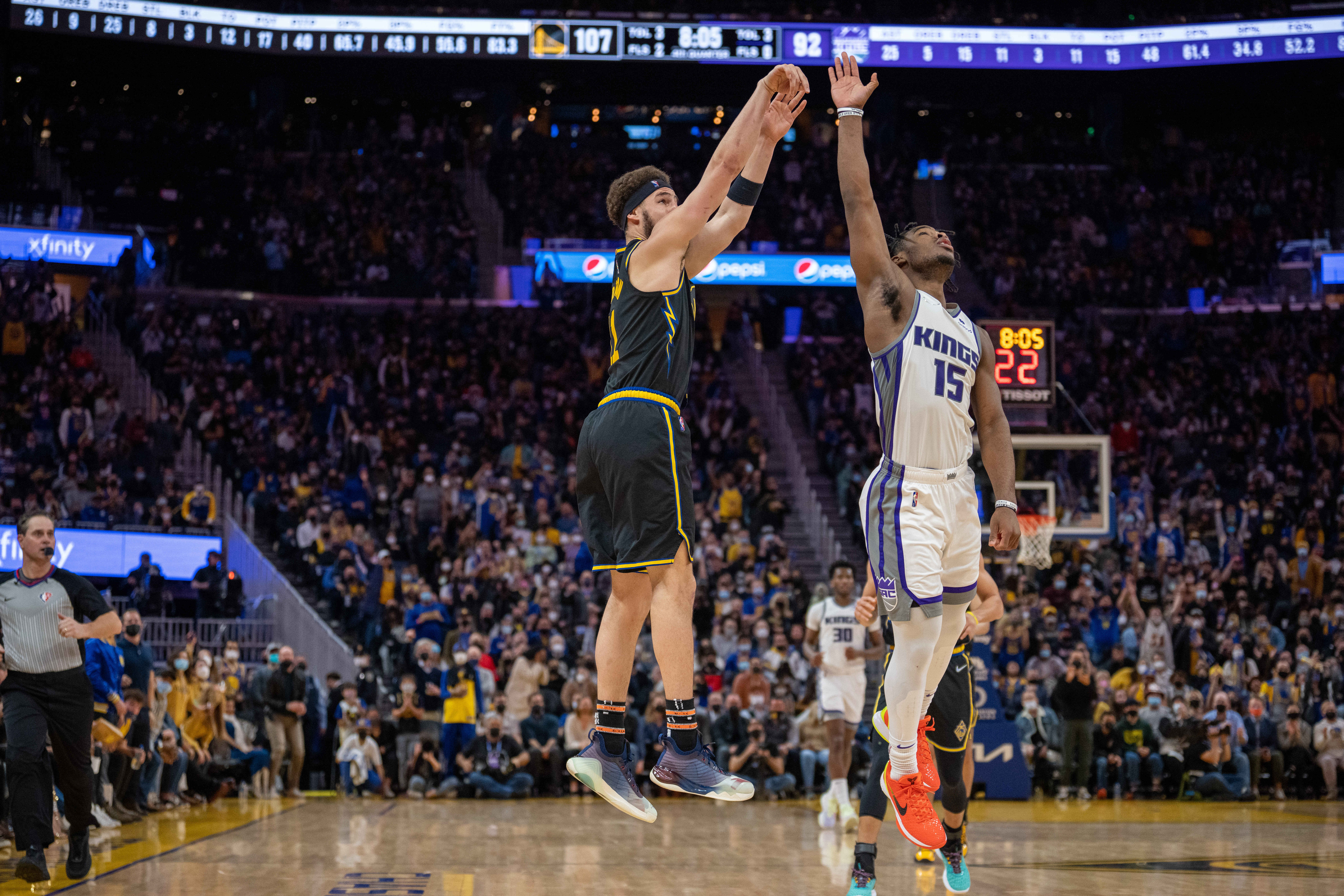 Feb 3, 2022; San Francisco, California, USA; Golden State Warriors guard Klay Thompson (11) shoots a three point basket during the fourth quarter against Sacramento Kings guard Davion Mitchell (15) at Chase Center. Mandatory Credit: 