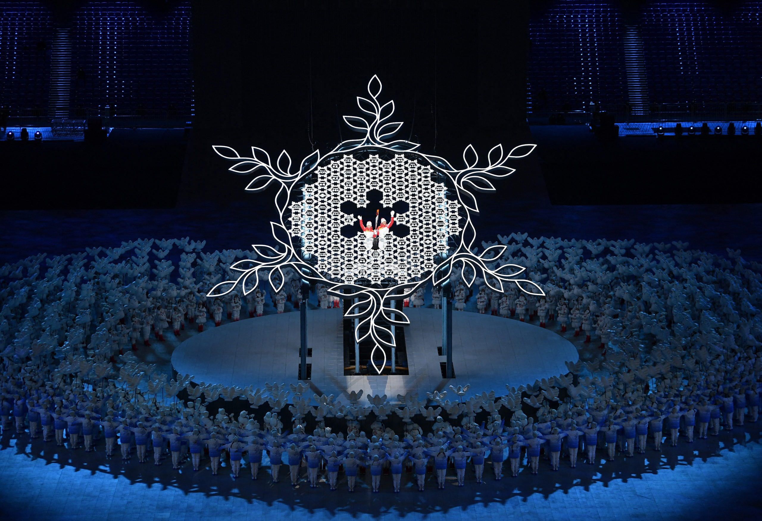 2022 Beijing Olympics - Opening Ceremony - National Stadium, Beijing, China - February 4, 2022. Torchbearers Zhao Jiawen and Dinigeer Yilamujiang hold the Olympic torch during the opening ceremony. 