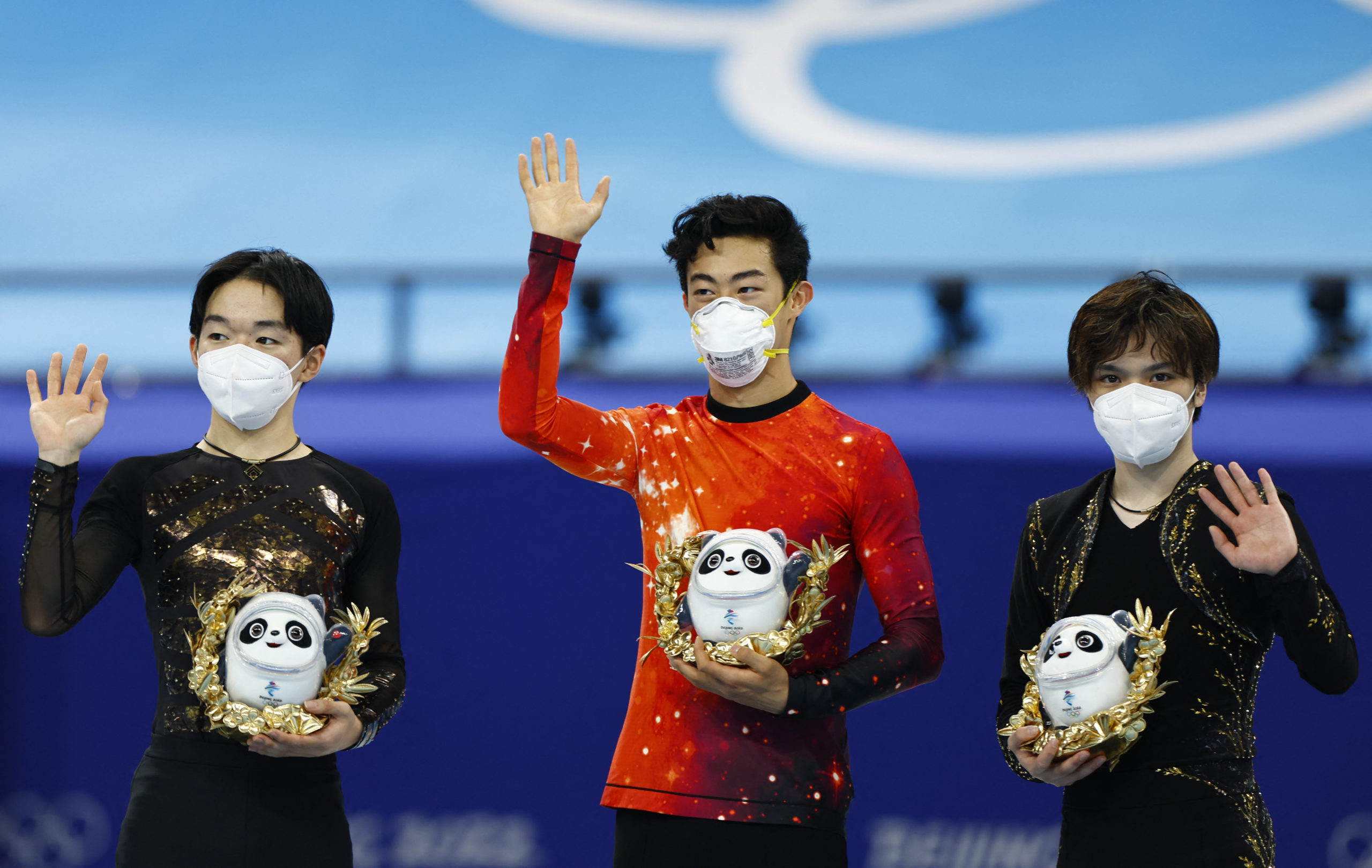 s celebrates on the podium next to silver medallist Yuma Kagiyama of Japan and bronze medallist Shoma Uno of Japan.