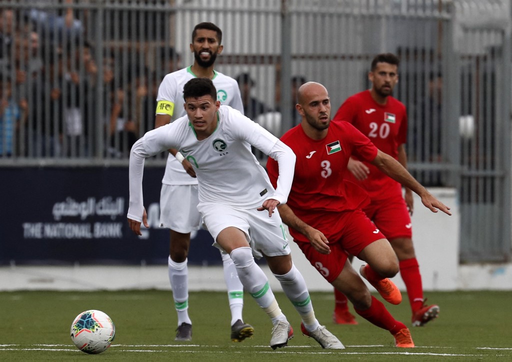 Saudi player Abdullah Abdulrahman Alhamddan views for the ball with Palestinian player Mohammed Rashid during a World Cup 2022 Asian qualifying match between Palestine and Saudi Arabia in the town of al-Ram in the Israeli occupied West Bank on October 15, 2019. 