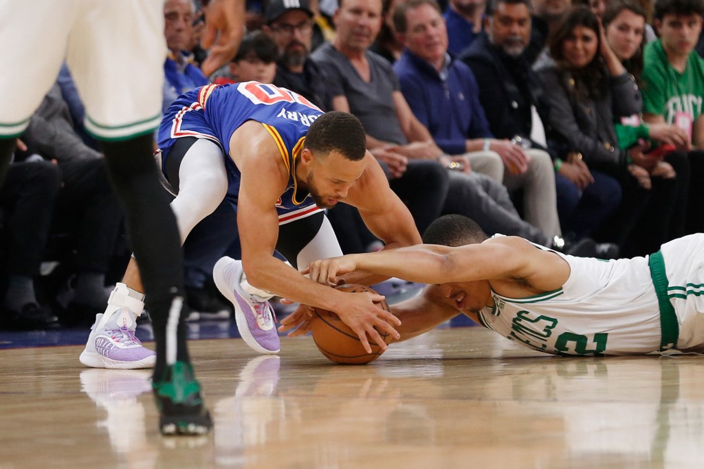 (FILES) In this file photo taken on March 15, 2022 Stephen Curry #30 of the Golden State Warriors competes for a loose ball against Grant Williams #12 of the Boston Celtics in the first quarter at Chase Center in San Francisco, California.