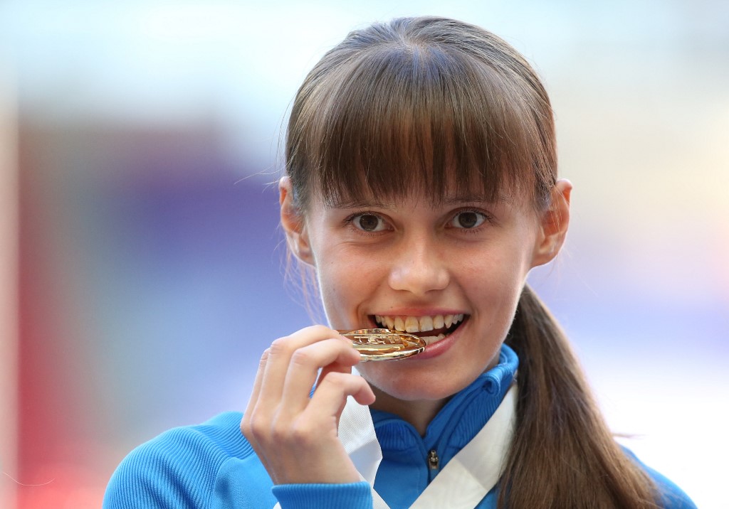 Russia's Elena Lashmanova bites her gold medal on the podium during the medal ceremony for the women's 20 kilometres walk at the 2013 IAAF World Championships at the Luzhniki stadium in Moscow on August 13, 2013. 