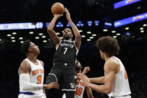 Kevin Durant #7 of the Brooklyn Nets shoots the ball as RJ Barrett #9 and Jericho Sims #45 of the New York Knicks defend during the first half at Barclays Center on March 13, 2022 in the Brooklyn borough of New York City. NOTE TO USER: User expressly acknowledges and agrees that, by downloading and or using this photograph, User is consenting to the terms and conditions of the Getty Images License Agreement.   Sarah Stier/Getty Images/AFP (Photo by Sarah Stier / GETTY IMAGES NORTH AMERICA / Getty Images via AFP)