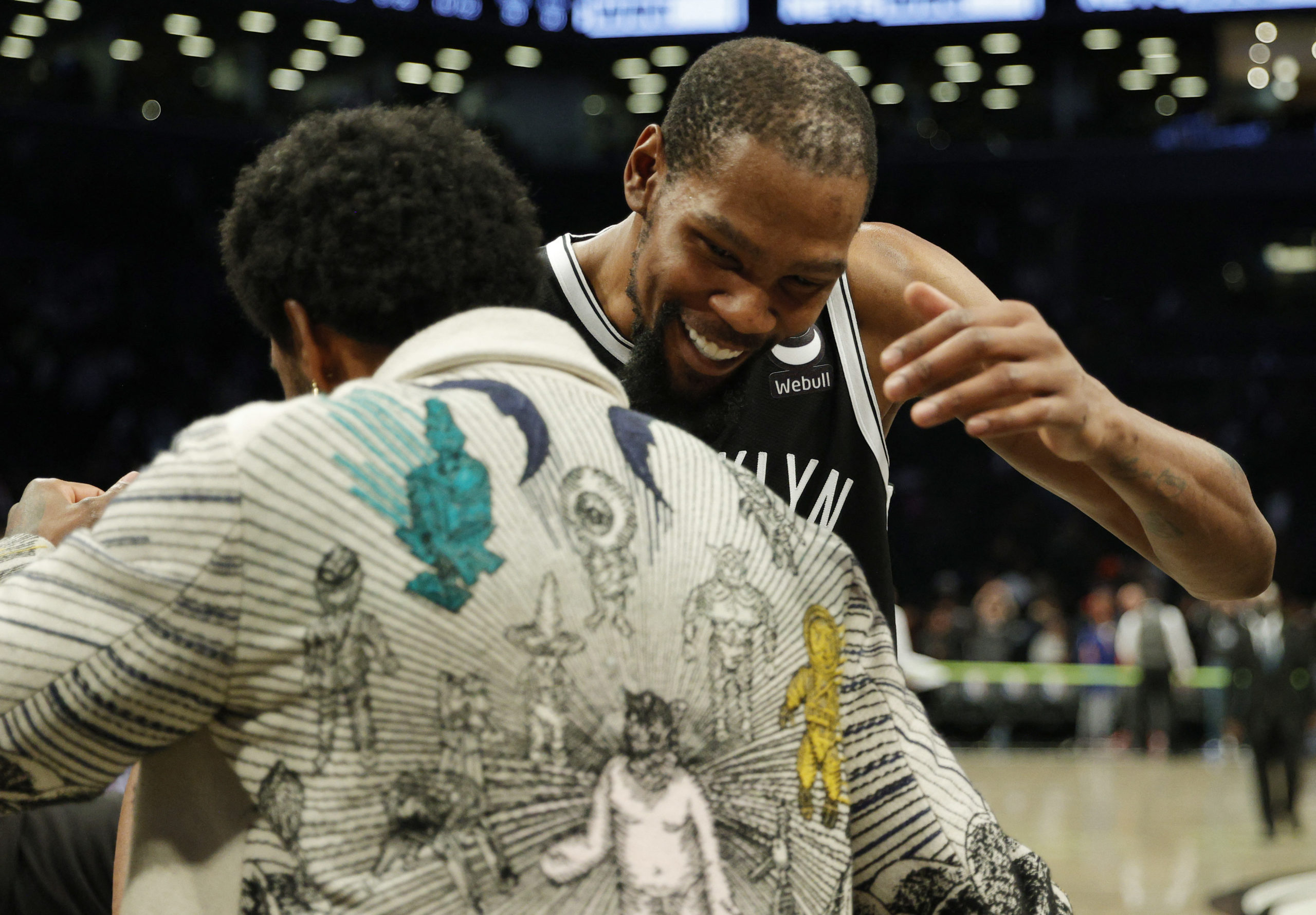 Kevin Durant #7 of the Brooklyn Nets hugs Kyrie Irving #11 after the second half against the New York Knicks at the Barclays Center on March 13, 2022 in the Brooklyn borough of New York City.  Nets won 110-107.  NOTE TO USERS: User expressly acknowledges and agrees that, by downloading and or using this image, User agrees to the terms and conditions of the Getty Images License Agreement.  Sarah Stier / Getty Images / AFP (Photo by Sarah Stier / GET IMAGES of North America / Getty Images via AFP)
