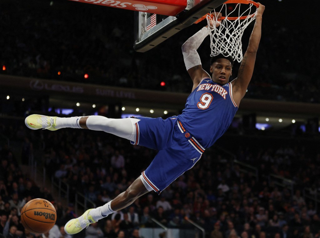 RJ Barrett #9 of the New York Knicks hangs on the basket after dunking during the second half against the Portland Trail Blazers at Madison Square Garden on March 16, 2022 in New York City. 