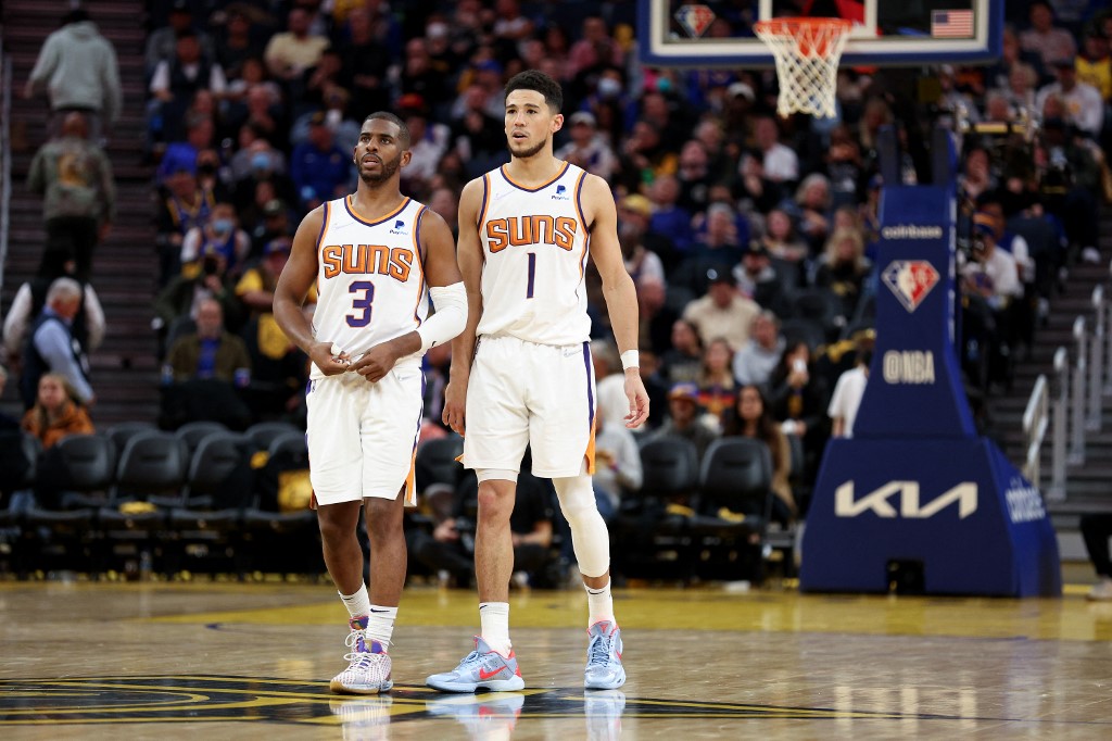 Chris Paul #3 and Devin Booker #1 of the Phoenix Suns stand on the court during their game against the Golden State Warriors in the second half at Chase Center on March 30, 2022 in San Francisco, California.