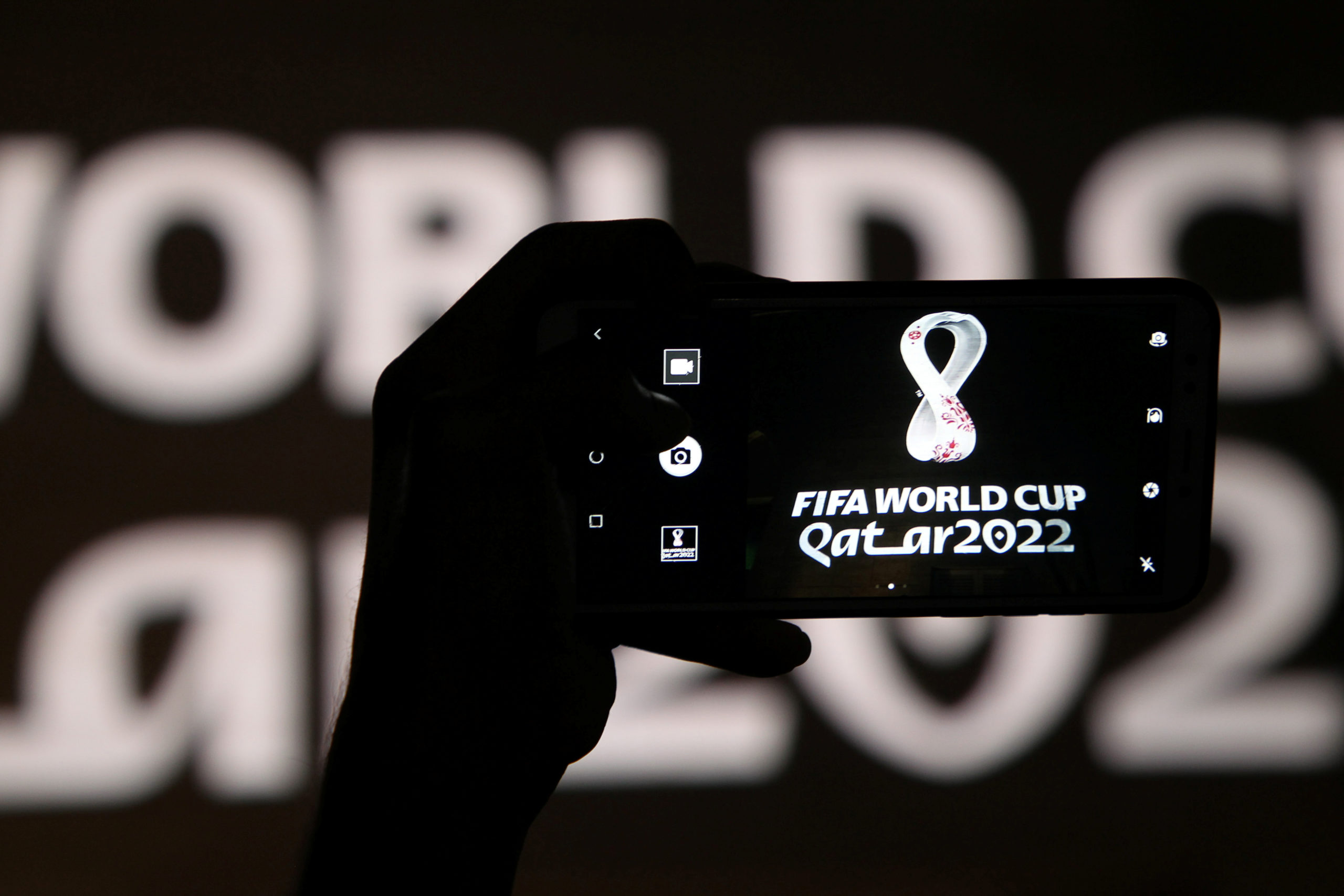 Un hombre toma una foto del logo oficial del torneo para la Copa Mundial de Qatar 2022 como se muestra en la pared del anfiteatro, en Doha, Qatar, el 3 de septiembre de 2019.