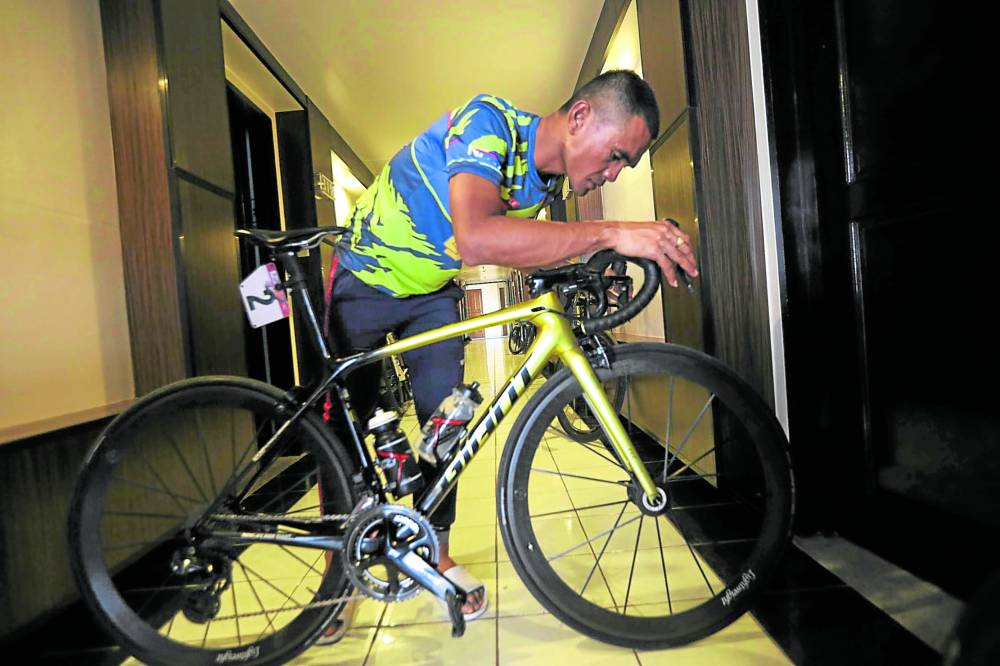 Ronald Oranza takes his bike out of his hotel room for a light workout. 