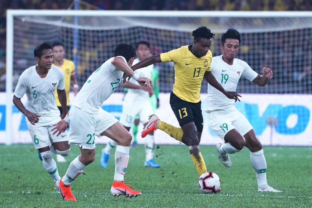 Malaysia's Mohamadou Sumareh (C) fights for the ball with Indonesian players during the Qatar 2022 FIFA World Cup qualifying football match between Malaysia and Indonesia at the Bukit Jalil Stadium in Bukit Jalil on November 19, 2019.