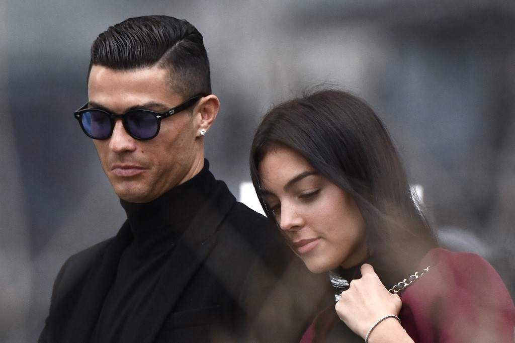 (FILES) In this file photo taken on January 22, 2019 Juventus' forward and former Real Madrid player Cristiano Ronaldo leaves with his Spanish girlfriend Georgina Rodriguez after attending a court hearing for tax evasion in Madrid. -