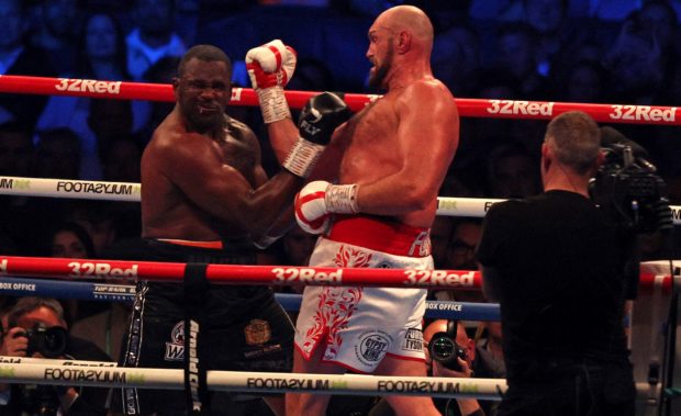 Britain's Tyson Fury (R) lands a punch to knockout Britain's Dillian Whyte in the sixth round and win their WBC heavyweight title fight at Wembley Stadium in west London, on April 23, 2022. - Tyson Fury stopped British rival Dillian Whyte in the sixth round to retain his WBC heavyweight crown at a packed Wembley on Saturday. In his first fight on UK soil in four years, Fury was treated to a hero's welcome by a 94,000-capacity crowd and largely dictated the tempo before ending proceedings in devastating fashion. (Photo by Adrian D
