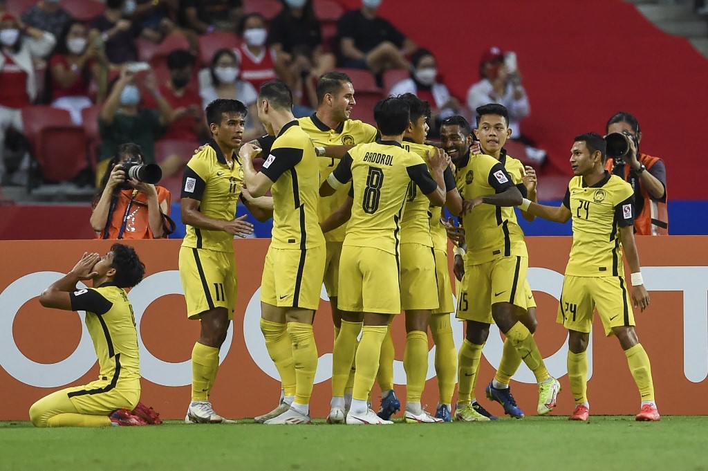 Malaysia's Kogileswaran Raj Mohana Raj (3R) celebrates with teammates after scoring a goal during the AFF Suzuki Cup 2020 Group B football match between Malaysia and Indonesia at the National Stadium in Singapore on December 19, 2021.