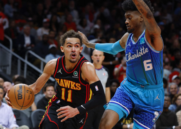 Trae Young #11 of the Atlanta Hawks dribbles the ball against Jalen McDaniels #6 of the Charlotte Hornets during the second half at State Farm Arena on April 13, 2022 in Atlanta, Georgia. NOTE TO USER: User expressly acknowledges and agrees that, by downloading and or using this photograph, User is consenting to the terms and conditions of the Getty Images License Agreement.   Todd Kirkland/Getty Images/AFP (Photo by Todd Kirkland / GETTY IMAGES NORTH AMERICA / Getty Images via AFP)