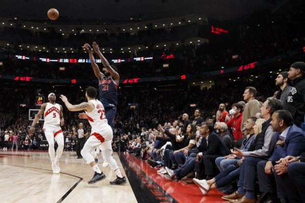 Joel Embiid #21 of the Philadelphia 76ers puts up a shot over Precious Achiuwa #5 and Fred VanVleet #23 of the Toronto Raptors in the final seconds of overtime in Game Three of the Eastern Conference First Round at Scotiabank Arena on April 20, 2022 in Toronto, Canada. 