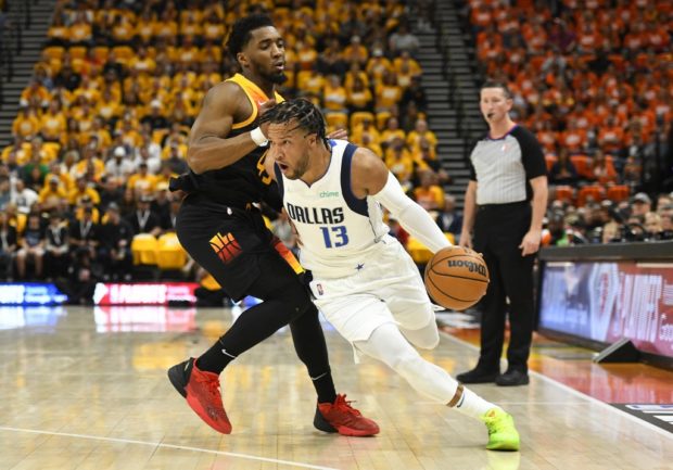 Jalen Brunson #13 of the Dallas Mavericks drives into Donovan Mitchell #45 of the Utah Jazz during the first half of Game Three of the Western Conference First Round Playoffs at Vivint Smart Home Arena on April 21, 2022 in Salt Lake City, Utah. 