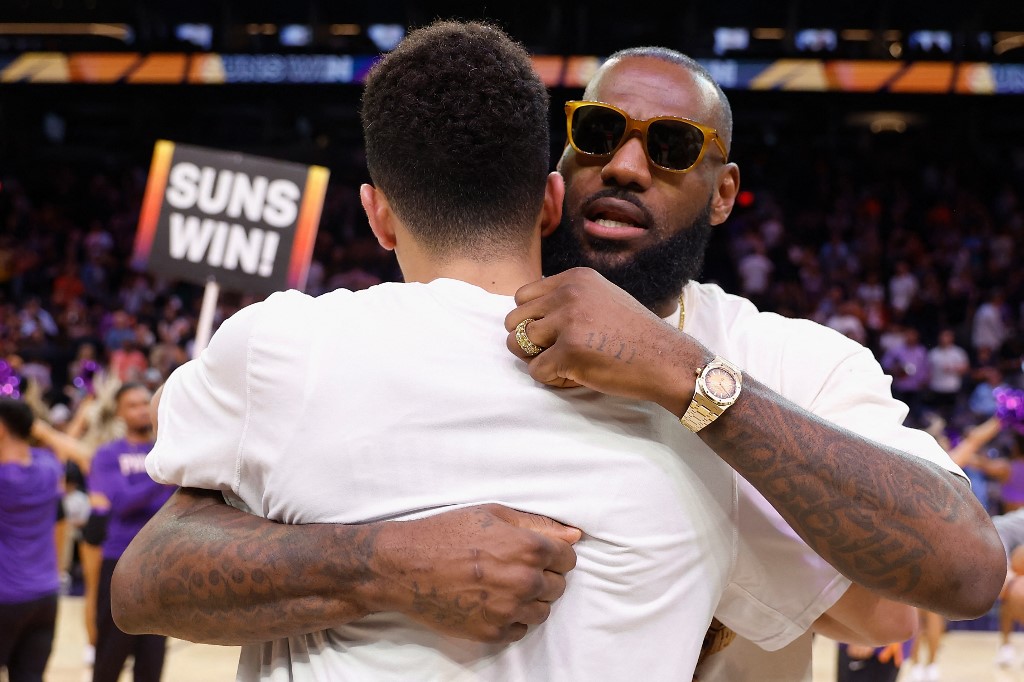 PHOENIX, ARIZONA - APRIL 05: LeBron James #6 of the Los Angeles Lakers hugs Devin Booker #1 of the Phoenix Suns following the NBA game at Footprint Center on April 05, 2022 in Phoenix, Arizona.