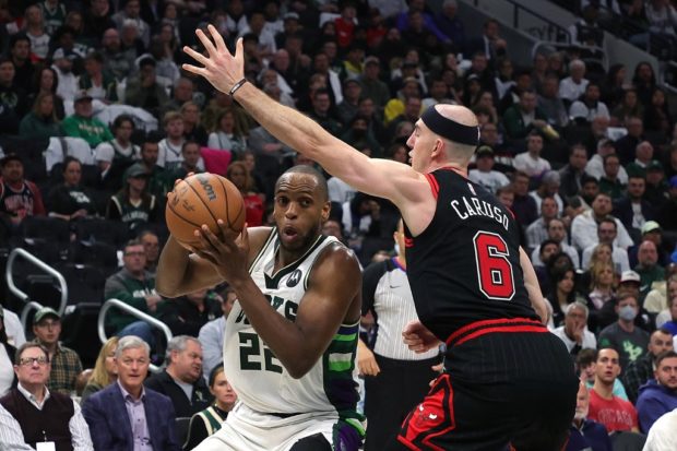 Khris Middleton #22 of the Milwaukee Bucks is defended by Alex Caruso #6 of the Chicago Bulls in the second half of Game Two of the Eastern Conference First Round Playoffs at Fiserv Forum on April 20, 2022 in Milwaukee, Wisconsin. N
