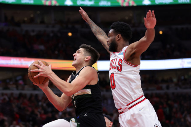 Grayson Allen #7 of the Milwaukee Bucks is defended by Coby White #0 of the Chicago Bulls during the second quarter of Game Three of the Eastern Conference First Round Playoffs at the United Center on April 22, 2022 in Chicago, Illinois. NOTE TO USER: User expressly acknowledges and agrees that, by downloading and or using this photograph, User is consenting to the terms and conditions of the Getty Images License Agreement.   Stacy Revere/Getty Images/AFP (Photo by Stacy Revere / GETTY IMAGES NORTH AMERICA / Getty Images via AFP)