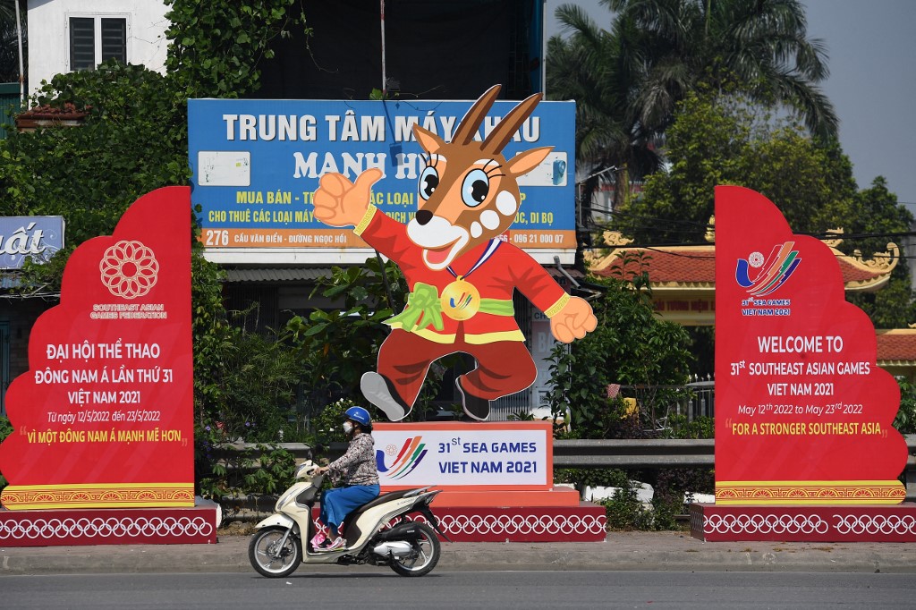 A woman rides past banners for the upcoming 31st Southeast Asian Games (SEA Games) in Hanoi on May 4, 2022, before the start of the multi-sport event on May 12