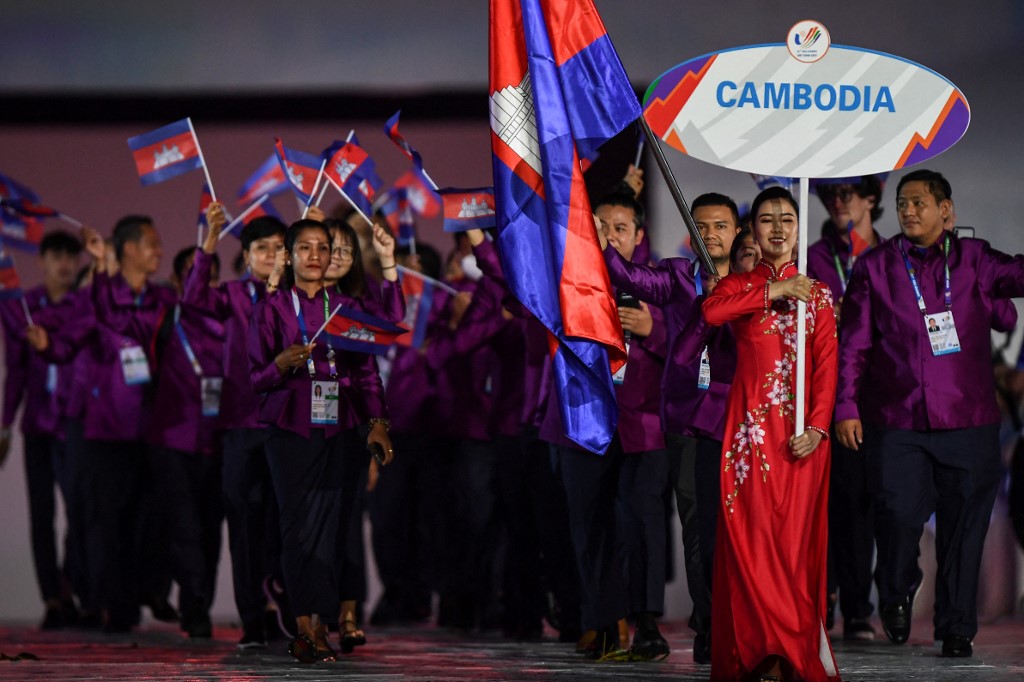 Members of the Cambodia contingent hold their national flags during the opening ceremony of the 31st Southeast Asian Games (SEA Games) at the My Dinh National Stadium in Hanoi on May 12, 2022. (Photo by Nhac NGUYEN / AFP)
