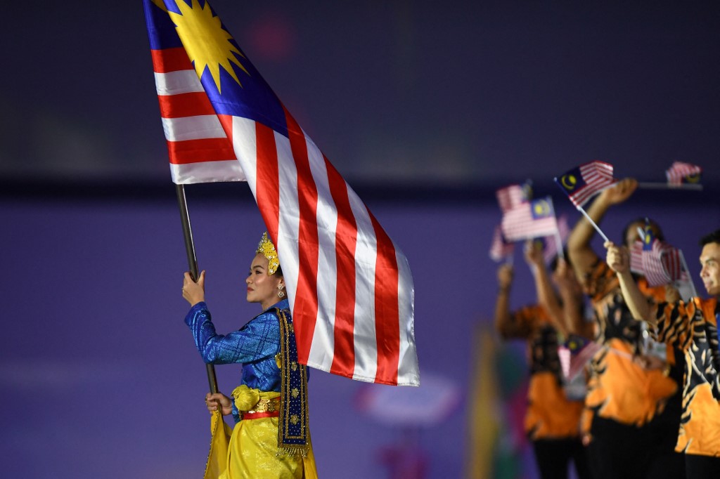 Malaysia's flagbearer holds the national flag during the opening ceremony of the 31st Southeast Asian Games (SEA Games) at the My Dinh National Stadium in Hanoi on May 12, 2022. (Photo by Nhac NGUYEN / AFP)