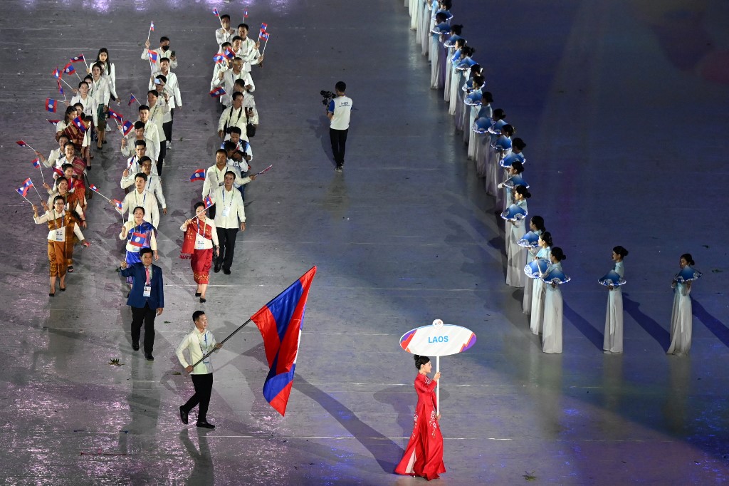 Members of the Laos contingent hold their national flags during the opening ceremony of the 31st Southeast Asian Games (SEA Games) at the My Dinh National Stadium in Hanoi on May 12, 2022. (Photo by Ye Aung THU / AFP)