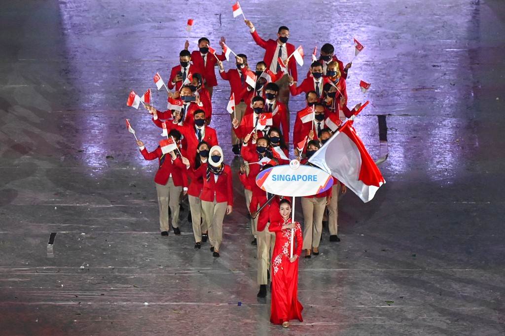 Members of the Singapore contingent wave their national flags during the opening ceremony of the 31st Southeast Asian Games (SEA Games) at the My Dinh National Stadium in Hanoi on May 12, 2022. (Photo by Ye Aung THU / AFP)