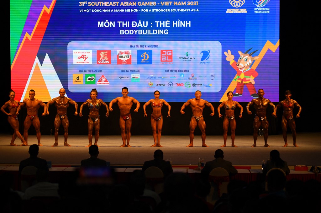 Competitors line up as they compete in the mixed pairs category of the bodybuilding event at the 31st Southeast Asian Games (SEA Games) in Hanoi on May 15, 2022. (Photo by Nhac NGUYEN / AFP)