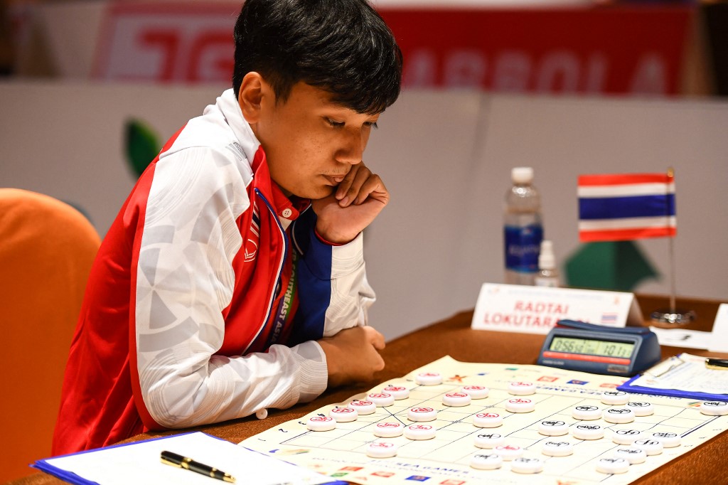 Thailand's Radtai Lokutarapol plans for a move as he competes with Malaysia's Tan Yu Huat in the men's standard single xiangqi event during the 31st Southeast Asian Games (SEA Games) in Hanoi on May 18, 2022. (Photo by Nhac NGUYEN / AFP)