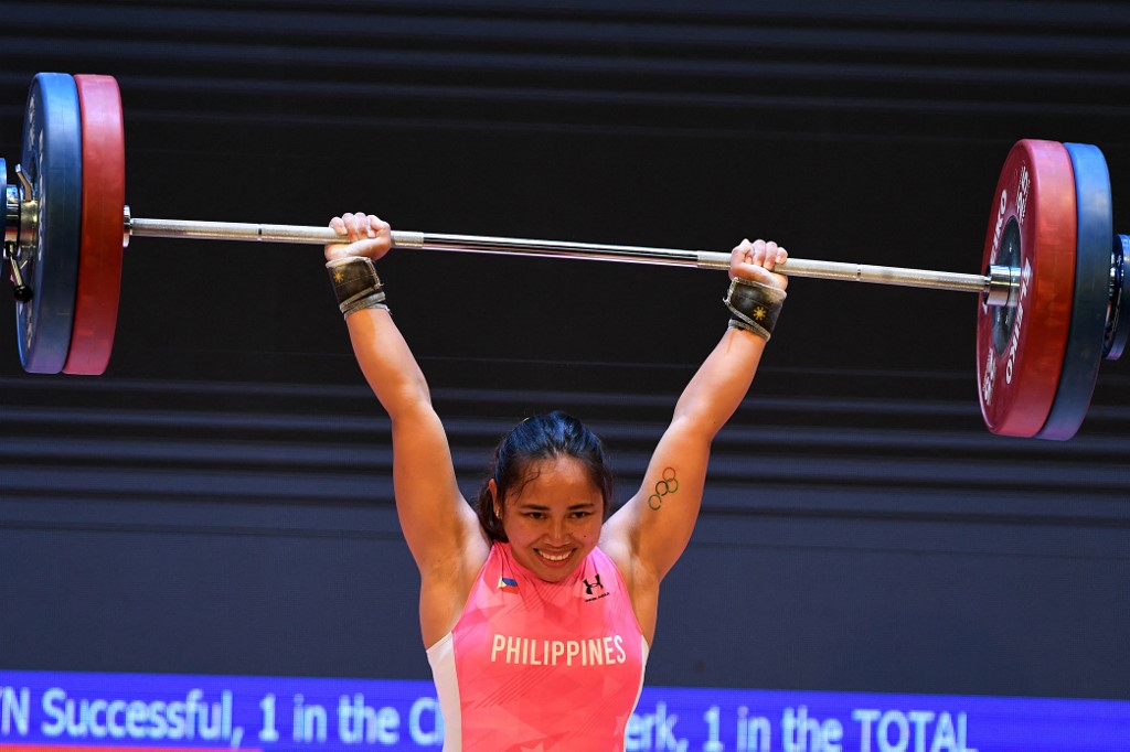 La filipina Hidilyn Diaz compite en el evento de levantamiento de pesas femenino de 55 kg durante los 31.º Juegos del Sudeste Asiático (SEA Games) en Hanoi el 20 de mayo de 2022. (Foto de Tang Chhin Sothy y TANG CHHIN SOTHY / AFP)