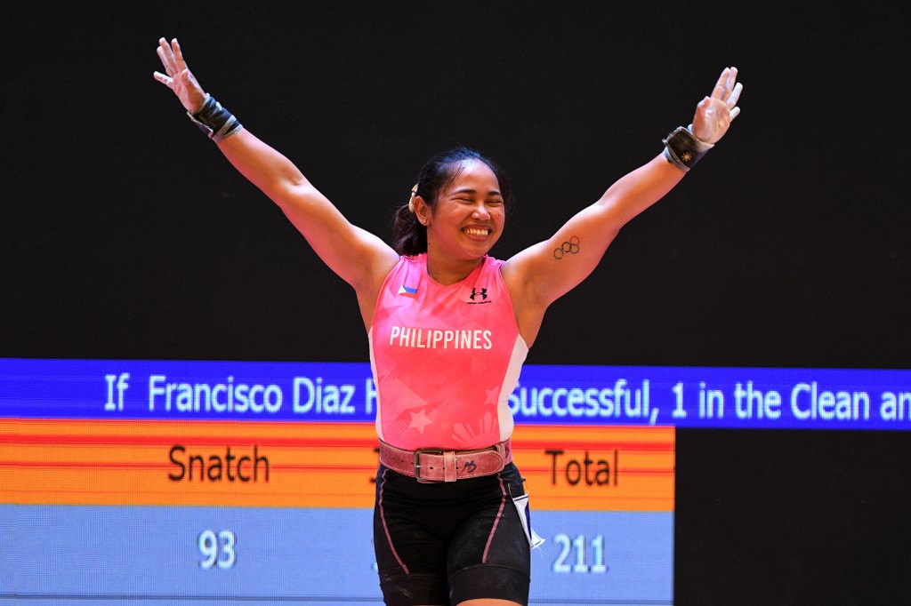 Philippines' Hidilyn Diaz celebrates as she wins gold in the women's 55kg weightlifting event during the 31st Southeast Asian Games (SEA Games) in Hanoi on May 20, 2022. (Photo by Tang Chhin Sothy and TANG CHHIN SOTHY / AFP)